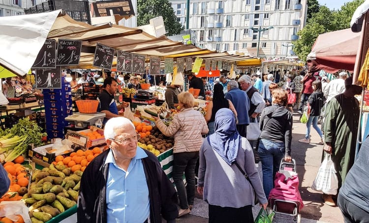 Marché en Algérie avec vendeurs et acheteurs, fruits et légumes frais.