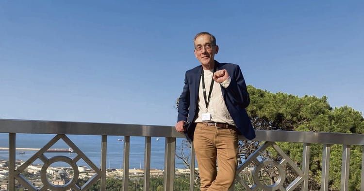 Pierre Audin souriant, portant un blazer, devant la mer et la nature.