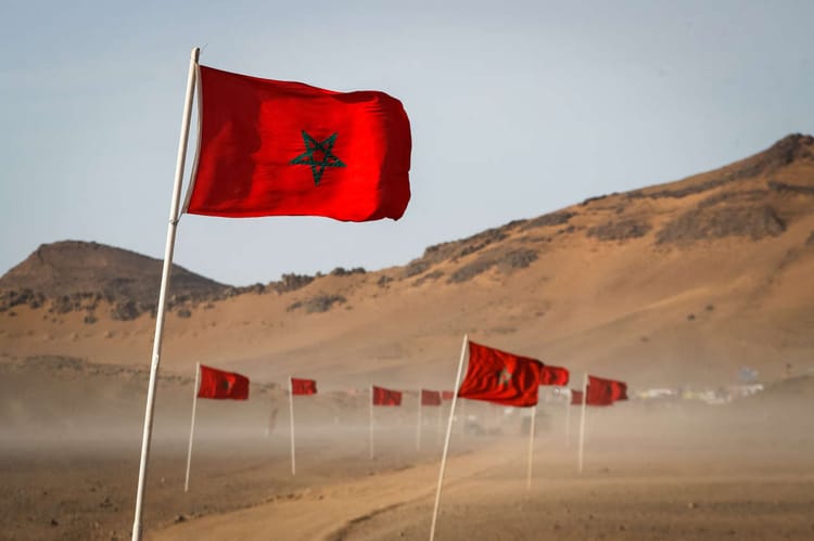 Drapeaux marocains flottant dans le désert aride.