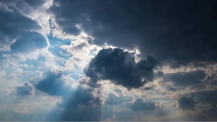 Ciel nuageux avec rayons de soleil perçant à travers les nuages.