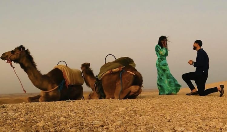 Maroc : Découvrez l'incroyable demande en mariage de Zeeko Zaki à sa princesse Renee Monaco Homme faisant une demande en mariage à une femme dans le désert avec des chameaux.