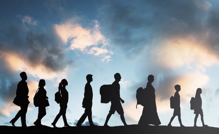 Immigration ! 422 000 immigrés expulsés du sol européen. Les algériens concernés dans l’embarras. Groupe de migrants marchant sous un ciel nuageux au coucher du soleil.