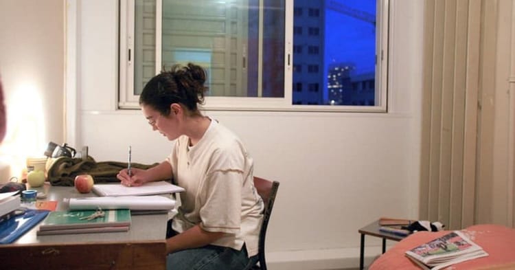 Femme étudiante travaillant à son bureau à domicile en soirée.