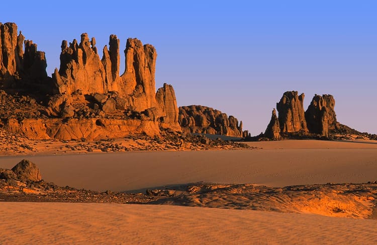 Paysage désertique avec formations rocheuses en Algérie au coucher du soleil.