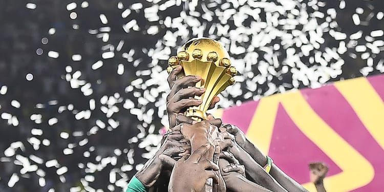 Organisation/CAN 2025 : le Maroc confirme que… l’Algérie se trouve dans de beaux draps Joueur levant le trophée de la CAN 2025 avec confettis en arrière-plan.