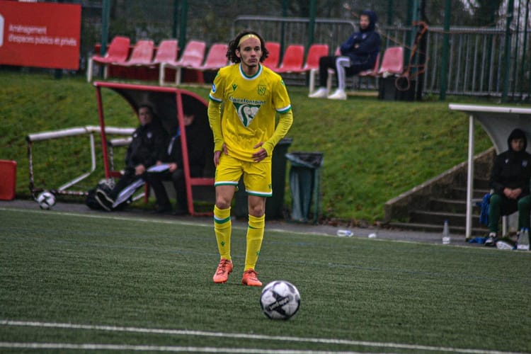 Younes Benali en action sur le terrain de football avec un ballon.