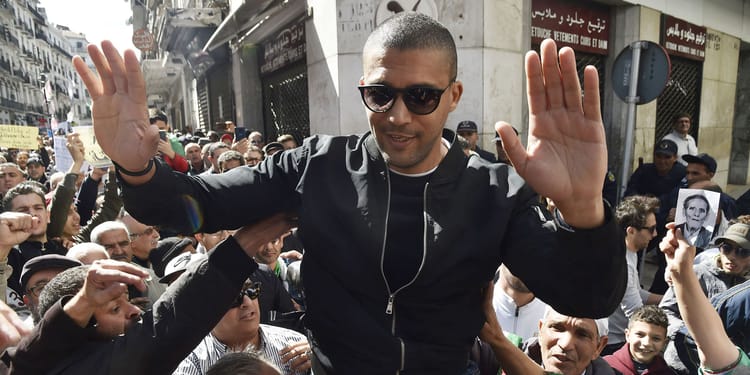 Khaled Drareni scellé en Algérie : pas de sortie hors territoire national Homme en sunglasses lors d'une manifestation en Algérie.
