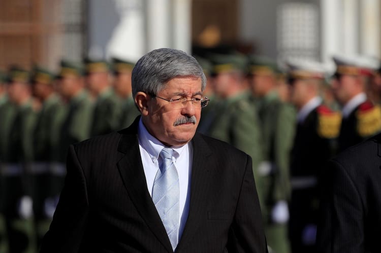 Ahmed Ouyahia en costume sombre lors d'une cérémonie militaire.