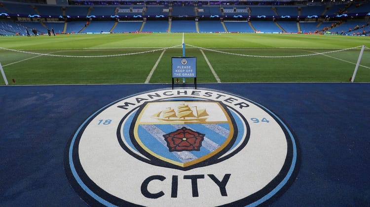 Vue du terrain de football de Manchester City avec le logo au sol.