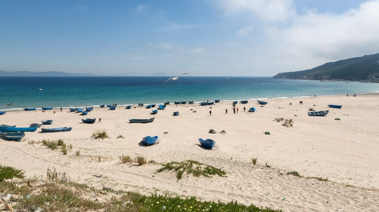 Maroc : ces plages sont à éviter cette année Plage de sable propre avec des bateaux abandonnés et une mer claire.