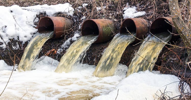 Écoulement d'eaux usées dans un environnement naturel en hiver.