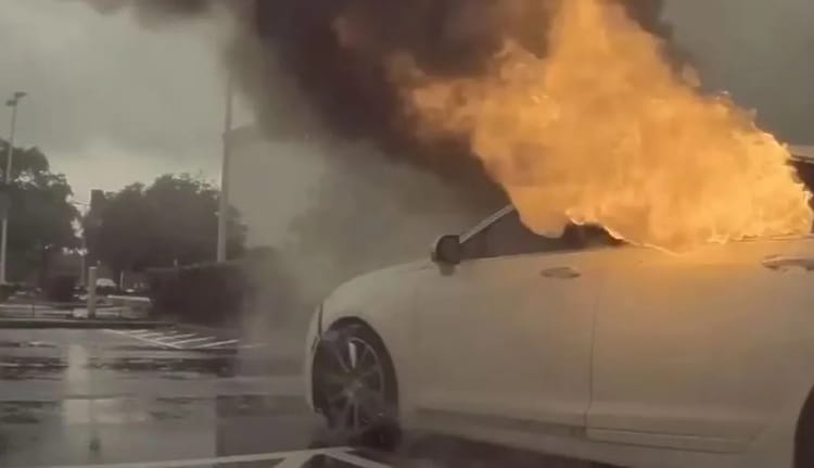 Voiture en feu lors d'une tempête orageuse.