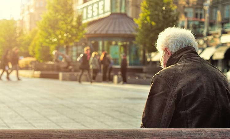 Retraités algériens : Quand la France décide de violer les accords de 1968 Homme âgé assis sur un banc dans une ville française.