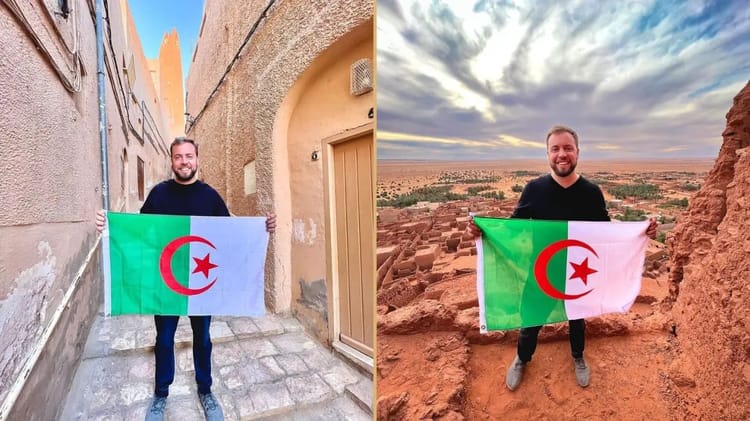 Touriste algérien tenant un drapeau en Maroc avec paysage désertique.