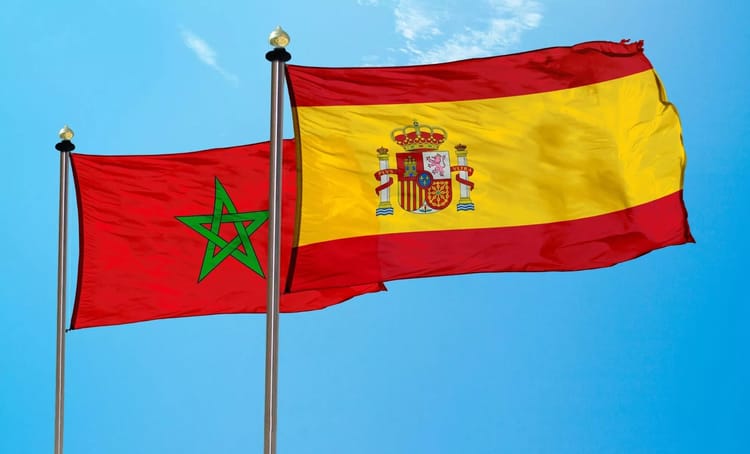 Drapeaux du Maroc et de l'Espagne flottant dans le ciel bleu.