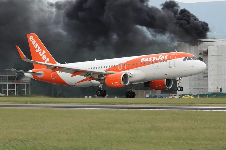 Avion EasyJet en atterrissage d'urgence avec fumée noire en arrière-plan.