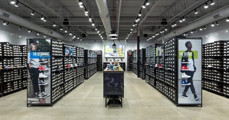 Magasin de chaussures avec rayons bien organisés et affiches promotionnelles.