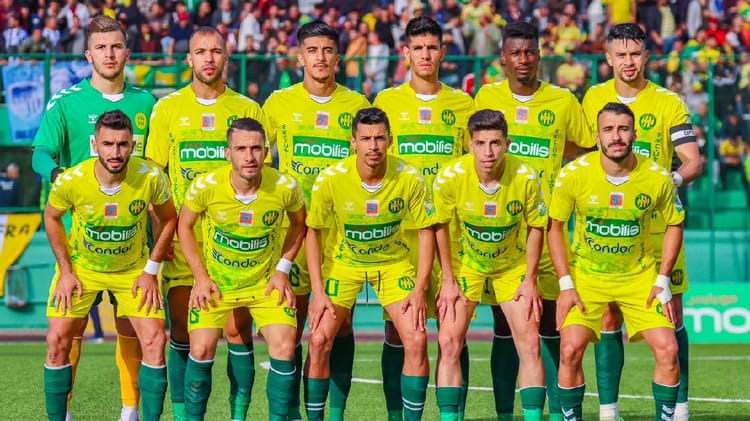 Groupe de joueurs de football en uniforme jaune et vert sur le terrain.