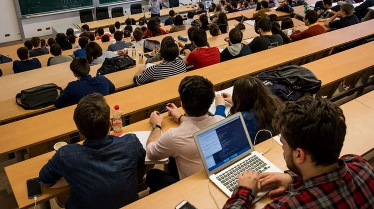 SOS : ayant perdu ses membres inférieurs dans un accident, cet étudiant algérien crie à l’aide. Étudiants en classe universitaire avec ordinateurs et notebooks.