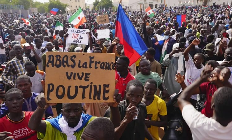 Grande manifestation en Afrique avec drapeaux et pancartes anti-français.