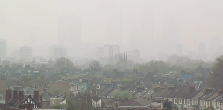 Ville africaine sous un ciel pollué avec brouillard dense.