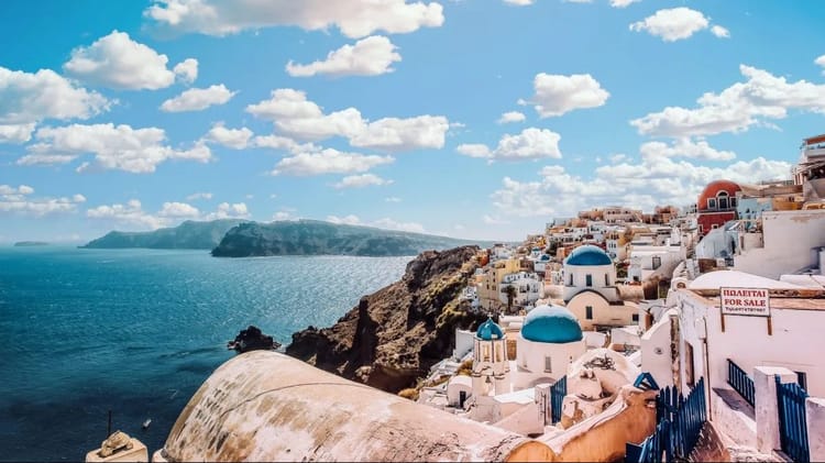 Algérienne de France : « Plutot l'Algérie que la Grèce » Paysage de Santorin avec maisons blanches et dômes bleus.