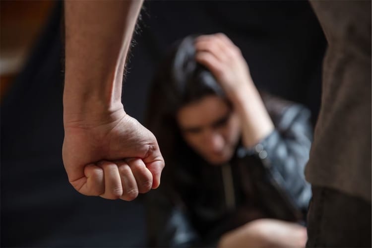 Femme en détresse avec un homme en arrière-plan, scène de violence.