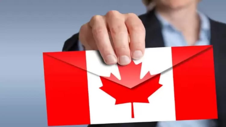 Main tenant une carte du Canada avec drapeau rouge et blanc.