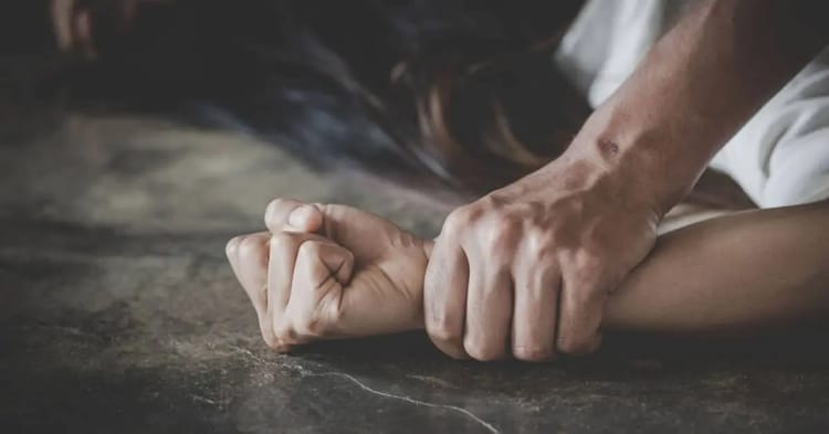 Main serrée en poing sur une surface sombre, scène de violence.