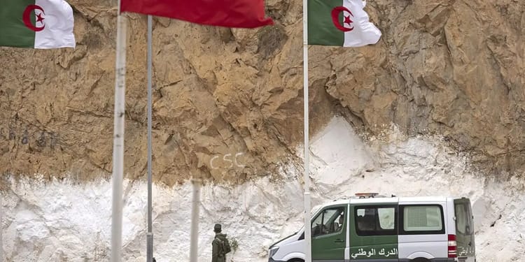 Véhicule militaire algérien devant un mur de roches.
