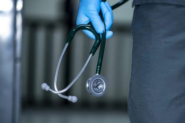 Médecin tenant un stéthoscope dans une clinique ou hôpital.