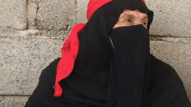 Une femme saoudienne s'inscrit à l'école à l'âge de 110 ans pour... Femme saoudienne âgée portant un voile noir et un foulard rouge.