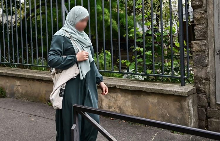 Femme en abaya avec hijab dans la rue en France.