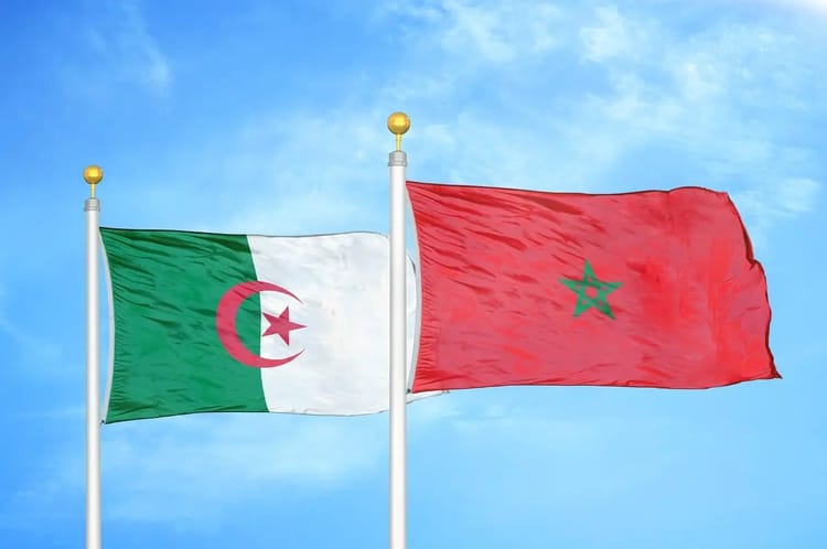 Drapeaux du Sahara marocain et de l'Algérie flottant dans le ciel bleu.