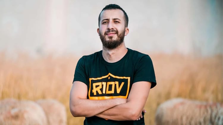 Anes Tina, youtubeur algérien, pose avec bras croisés en extérieur.