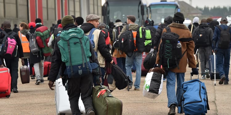 Migrants avec bagages attendant leur bus pour l'Europe.