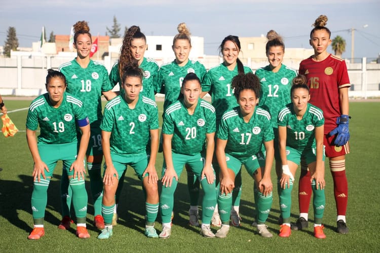 Groupe de joueuses de football algériennes en uniforme vert sur le terrain.
