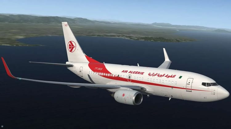 Avion Air Algérie survolant la mer avec paysage montagneux.