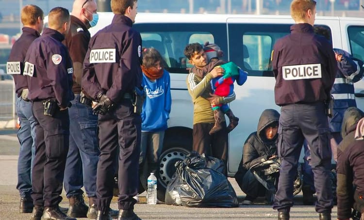 Policiers contrôlant des migrants dans une zone urbaine.