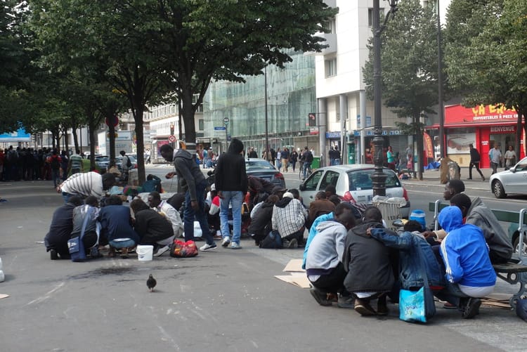 Groupe de personnes manifestant dans la rue pour la régularisation des sans-papiers.