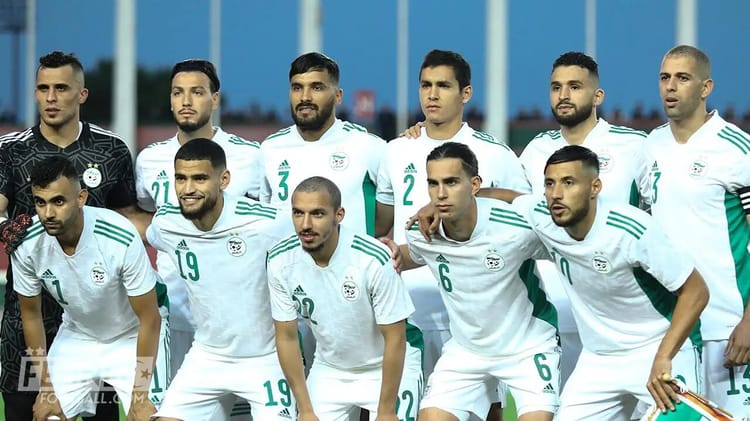 Groupe de joueurs de football marocains en tenue blanche sur le terrain.