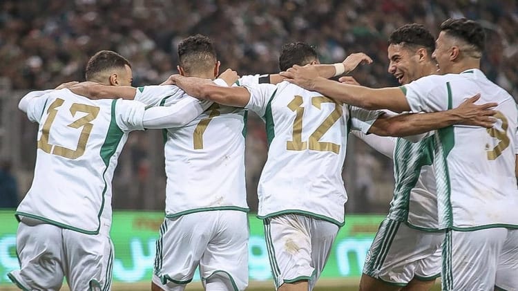 Les joueurs algériens célèbrent une victoire lors d'un match de football.