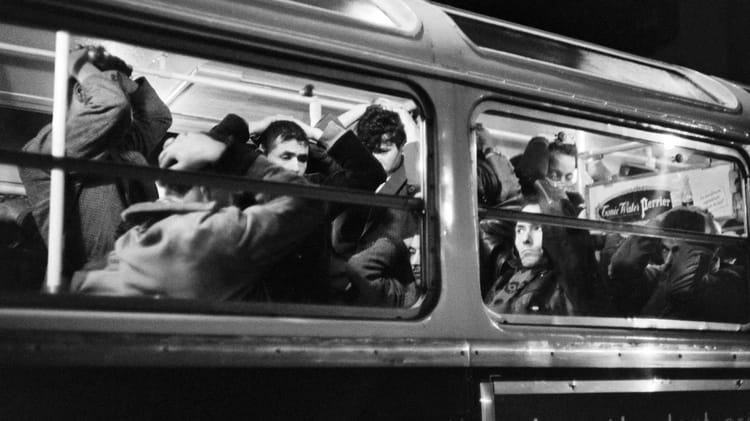 Manifestation d'Algériens à Paris en 1961 vue à travers une fenêtre de bus.