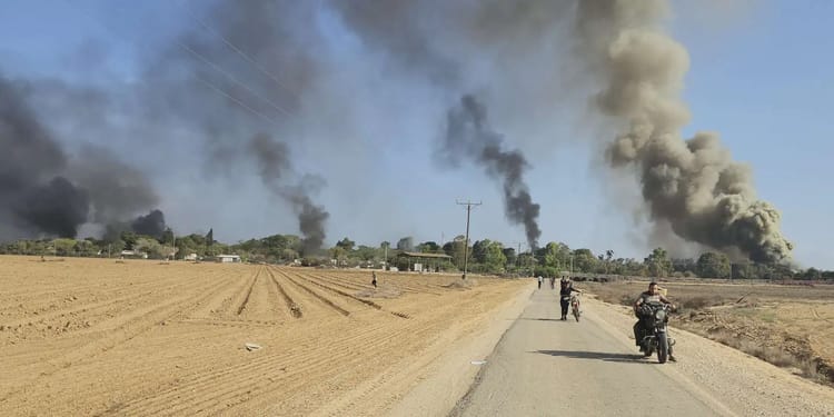Fumée noire et incendies dans un paysage rural en guerre.