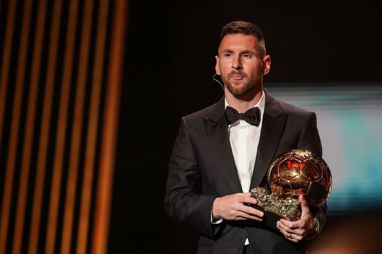 Lionel Messi remporte le Ballon d'Or 2023 : voici le Classement Complet Lionel Messi en costume noir tenant le Ballon d'Or lors de la cérémonie.