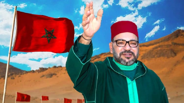 Homme marocain saluant avec drapeau national dans le désert.