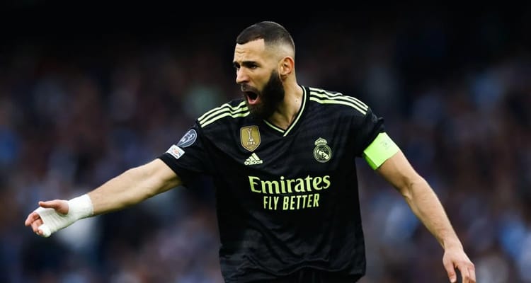 Karim Benzema célèbre en portant le maillot du Real Madrid.
