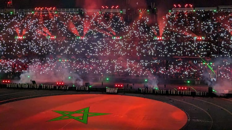 Cérémonie spectaculaire avec lumières et drapeau marocain.