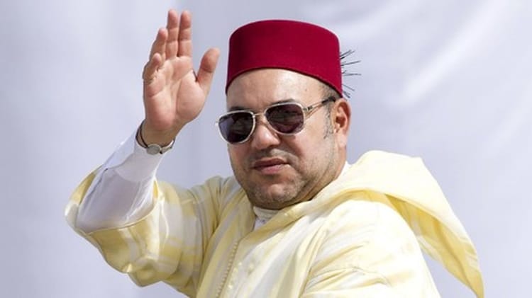 Homme portant fez, lunettes de soleil, saluant avec la main.