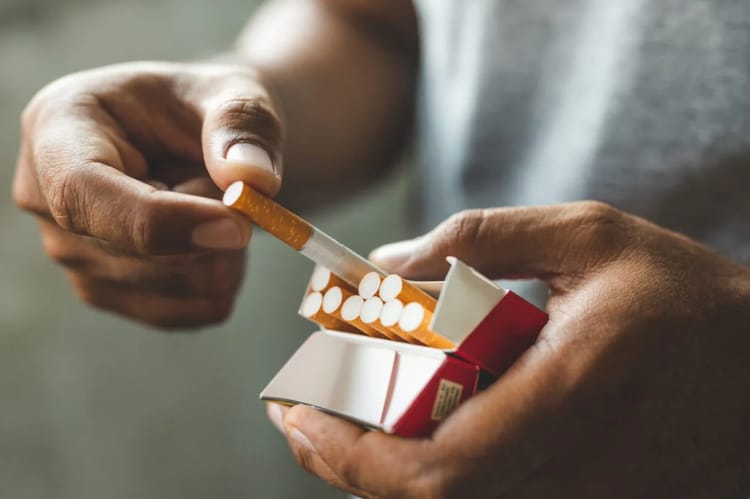 Augmentation des quotas de cigarettes pour les voyageurs : une bonne nouvelle pour les Algériens en Europe Main tenant une cigarette et une boîte d'allumettes.